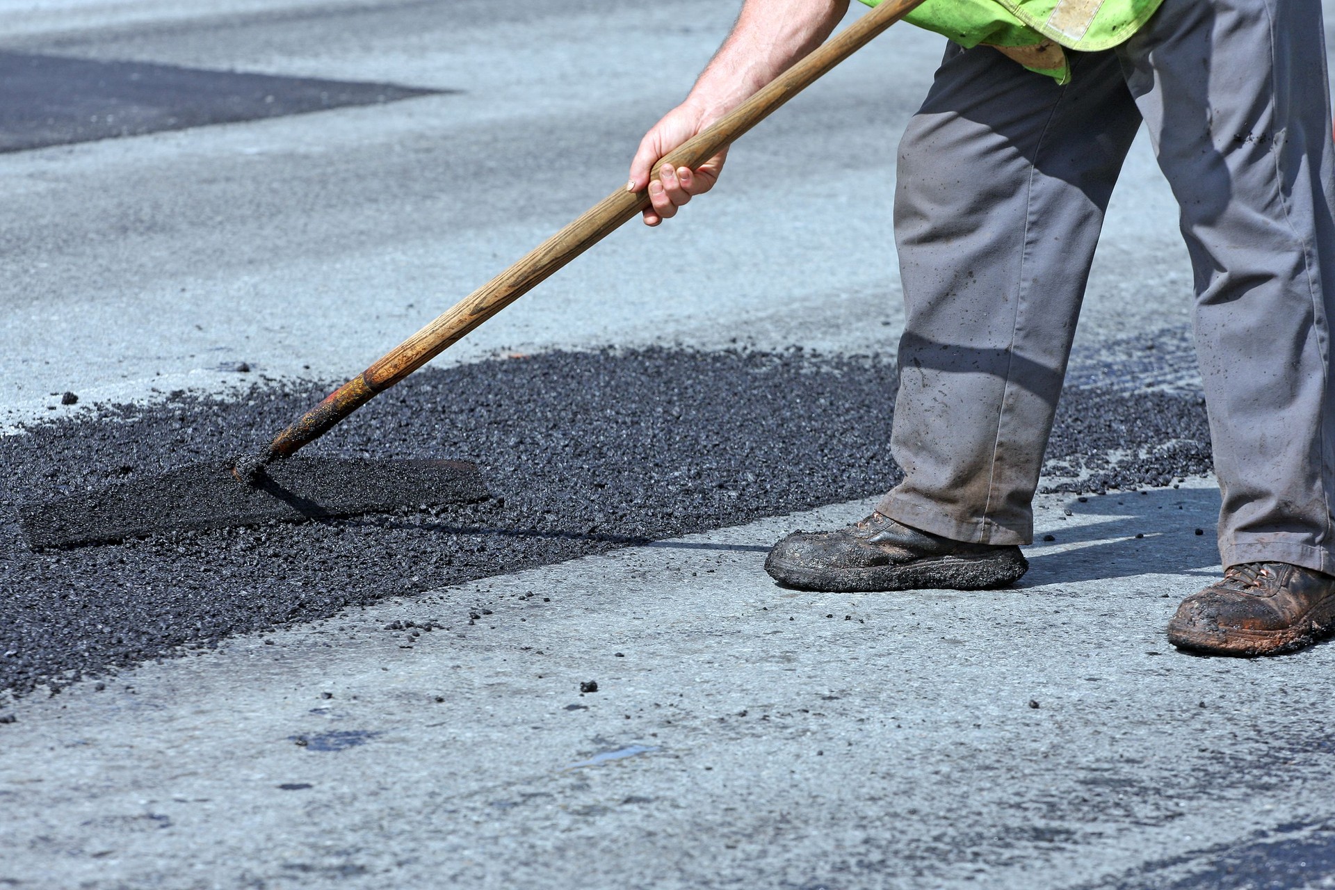 Spreading Hot Asphalt On A Pothole Repair Site